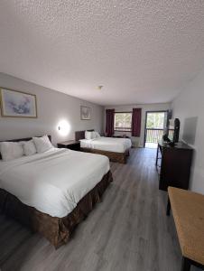 a hotel room with two beds and a balcony at Garden Inn Adairsville in Adairsville +3 photos