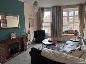 a living room with a couch and a fireplace at The Old Bakery in Sandwich