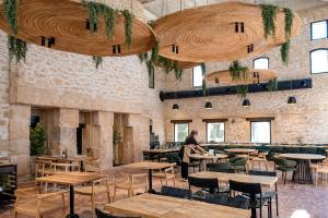 ein Restaurant mit Tischen und Stühlen und eine Person, die in einem Raum steht in der Unterkunft Tradere Hotel Boutique in Moncada