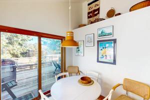 a dining room with a white table and a window at Charming oceanfront cottage with WiFi & easy beach access in Cannon Beach
