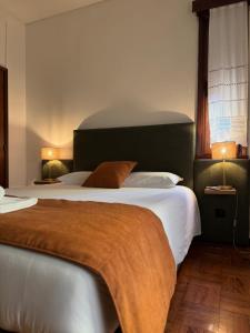 a bedroom with a large bed and two lamps at Casa do Ribeirinho in Amarante +191 photos
