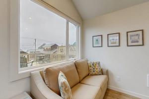 a living room with a couch and a large window at Dog-friendly comfy cabin only two blocks from the beach in Cannon Beach