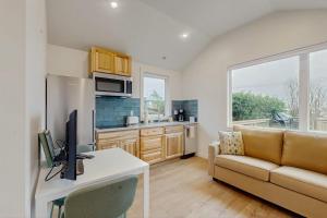 a living room with a couch and a desk with a computer at Dog-friendly comfy cabin only two blocks from the beach in Cannon Beach