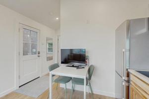 a kitchen with a white table and chairs and a refrigerator at Dog-friendly comfy cabin only two blocks from the beach in Cannon Beach