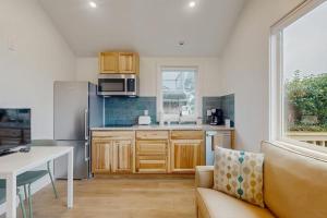 a kitchen with a couch and a table and a refrigerator at Dog-friendly comfy cabin only two blocks from the beach in Cannon Beach +7 photos