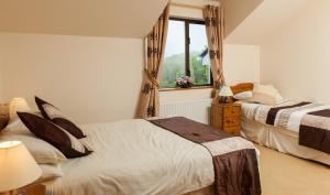 a bedroom with two beds and a window at Benbaun House in Clifden