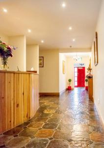 a hallway with a stone floor and a red door at Benbaun House in Clifden +6 photos