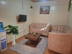 a living room with two couches and a coffee table at Larmar Homes- Kajiado in Kajiado