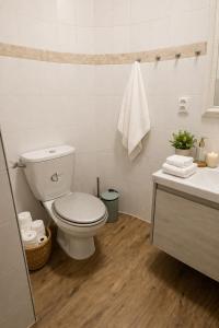 a white bathroom with a toilet and a sink at Via Room in Raszyn
