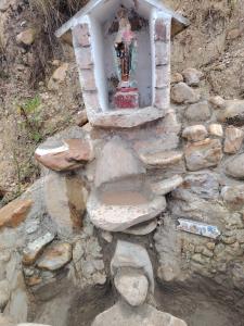 a small shrine on top of a rock wall at Salon de eventos cabaña el Chalet in Paipa