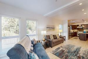 a living room with a blue couch and a kitchen at Stunner apt with fireplace grill partial ocean views & partial AC in Gold Beach