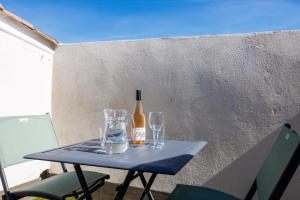 a bottle of wine and two glasses on a table at Apt Le Frene in Tourrettes-sur-Loup