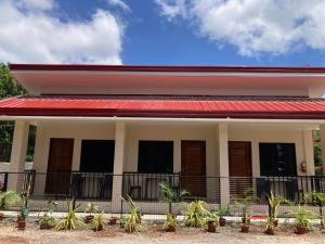 a house with a red roof and plants at Simon Guest House in San Juan +6 photos