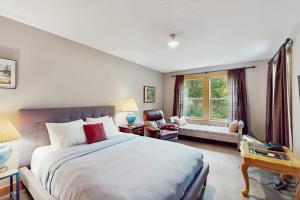 a bedroom with a large bed and a living room at Charming riverfront apartment with kitchenette grill & central AC in Welches