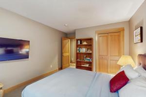 a bedroom with a large white bed with a red pillow at Charming riverfront apartment with kitchenette grill & central AC in Welches +14 photos