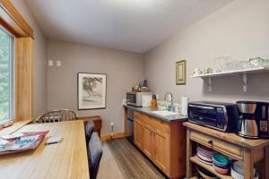 a kitchen with a counter and a table with a microwave at Charming riverfront apartment with kitchenette grill & central AC in Welches