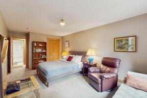a bedroom with a bed and a chair and a couch at Charming riverfront apartment with kitchenette grill & central AC in Welches