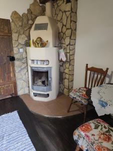 a living room with a fireplace and a chair at Agroturystyka LipoweWzgórze- Jaś&Małgosia in Tereszpol