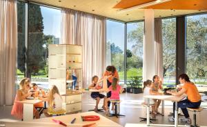 a group of children sitting at tables in a classroom at Maistra Select Family Hotel Amarin in Rovinj
