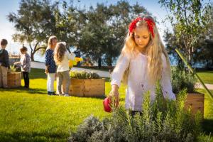 a little girl is standing in a garden at Maistra Select Family Hotel Amarin in Rovinj