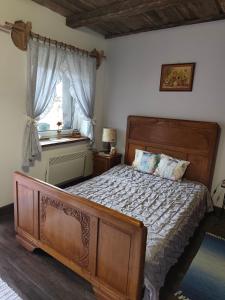 a bedroom with a wooden bed and a window at Agroturystyka LipoweWzgórze- Jaś&Małgosia in Tereszpol