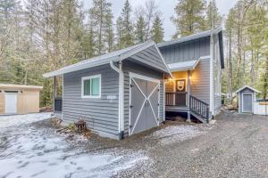 a tiny house with a garage and a driveway at Inviting studio with kitchenette & scenic forest setting in Welches