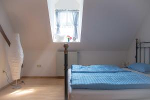 a bedroom with a bed with blue sheets and a window at Kuschelige Ferienwohnung in Schwandorf in Bayern