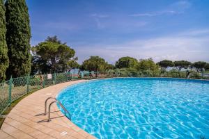 a large blue swimming pool with a fence around it at Club del Sole Desenzano Boutique Resort in Desenzano del Garda