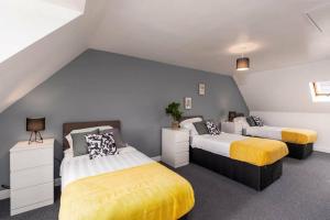 a bedroom with two beds with yellow and white at Hills Close - 3 Bed House - FREE Parking in Mexborough