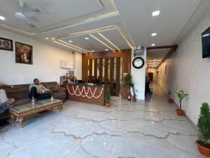 a man sitting on a couch in a living room at Shree Ram Palace in Chhatikara