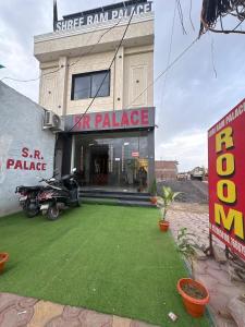 a building with a yard of grass in front of it at Shree Ram Palace in Chhatikara