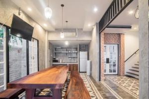 a kitchen with a long wooden table in a room at X9Hostel in Bangkok