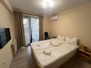 a bedroom with a bed with two towels on it at Topalov in Sandanski