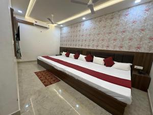 a bedroom with a large bed with red and white pillows at Shree Ram Palace in Chhatikara