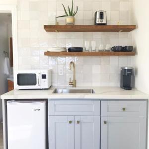 a white kitchen with a sink and a microwave at Serenity villa homes in Nairobi