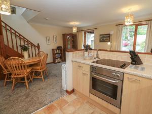 a kitchen with a table and a stove top oven at Two Hoots in Falmouth