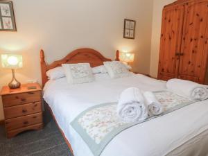a bedroom with a bed with towels on it at Two Hoots in Falmouth