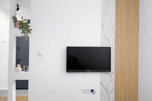 Ein Flachbildfernseher hängt an einer weißen Wand in der Unterkunft NeraHome in Banja Luka
