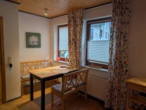 ein Esszimmer mit einem Tisch und einem Fenster in der Unterkunft FeWo Opolt mit Sauna in Medebach