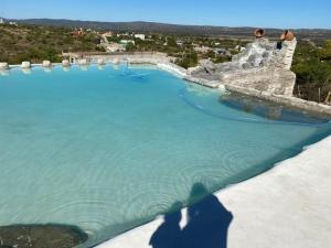 a shadow of a person taking a picture of a lake at Complejo Las Carolina in Arroyo de Los Patos