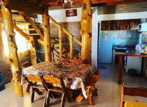 a dining room with a table and a kitchen at Complejo Las Carolina in Arroyo de Los Patos