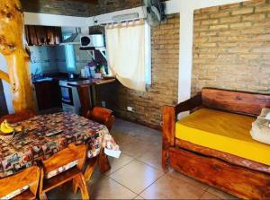 a room with a table and a bed and a kitchen at Complejo Las Carolina in Arroyo de Los Patos