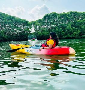 a woman is sitting on a kayak in the water at Star Varkala Homestay in Varkala