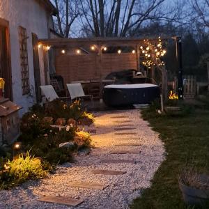 a backyard with a hot tub and a pergola with lights at Coume a Case - Maison de charme 4 étoiles - piscine et spa - vallée d'Ossau in Lys +88 photos