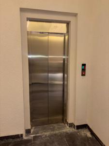 a metal elevator in a building with a green light at استديو تراحيب لبن للضيافة in Riyadh