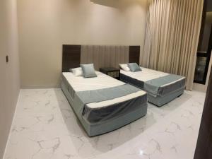 two beds in a hotel room with at استديو تراحيب لبن للضيافة in Riyadh +8 photos