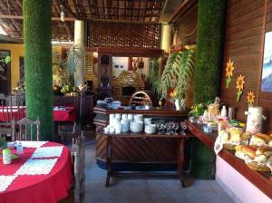 a restaurant with a table with food on it at Pousada Casarão Piúma in Piúma