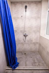 a shower with a blue curtain in a bathroom at The Best Hostel in Yerevan