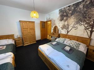 a bedroom with two beds and a painting on the wall at Dolina Rastoki in Koniaków
