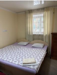 a bedroom with a bed with two towels on it at Fly Apart in (( Turksib ))